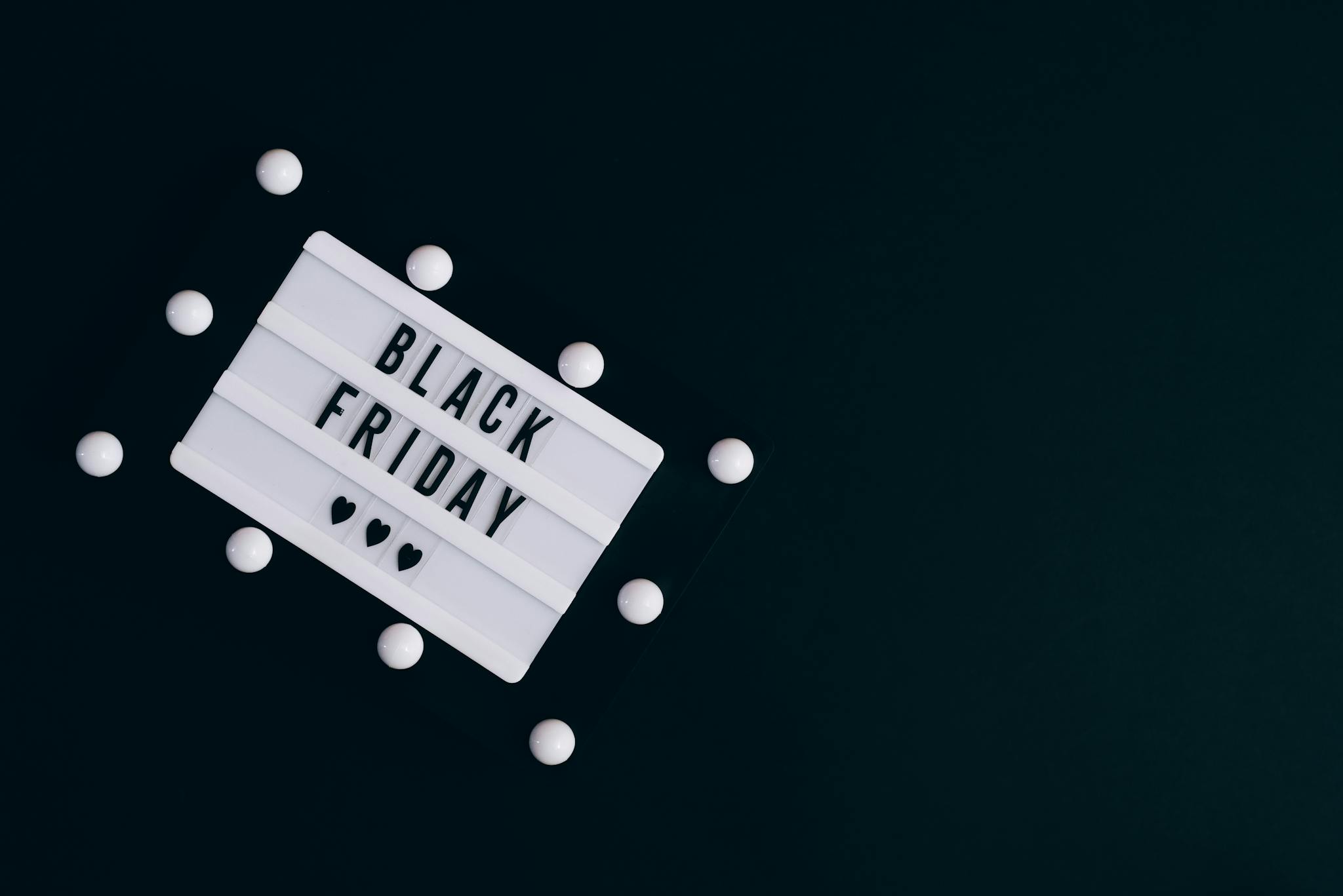 Black Friday sign on dark background with hearts for seasonal promotions.